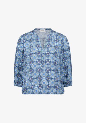 Blouse pour femmes à manches longues avec motif floral géométrique bleu et blanc, col en V et poignets élastiques sur fond blanc.