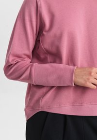 Rosa Sweatshirt mit langen Ärmeln, gerippten Bündchen und einer leicht lockeren Passform. Hergestellt aus weichem Baumwoll-Mischgewebe und mit einem schlichten Design.