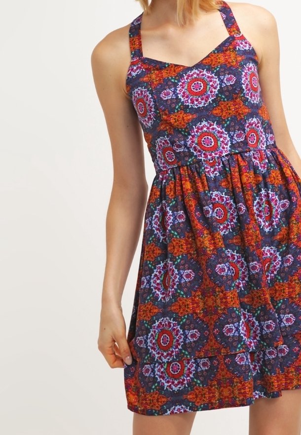 Robe imprimée florale avec un corsage ajusté, des bretelles larges et une jupe évasée. Les couleurs comprennent des motifs bleu marine, rouge, orange et vert.