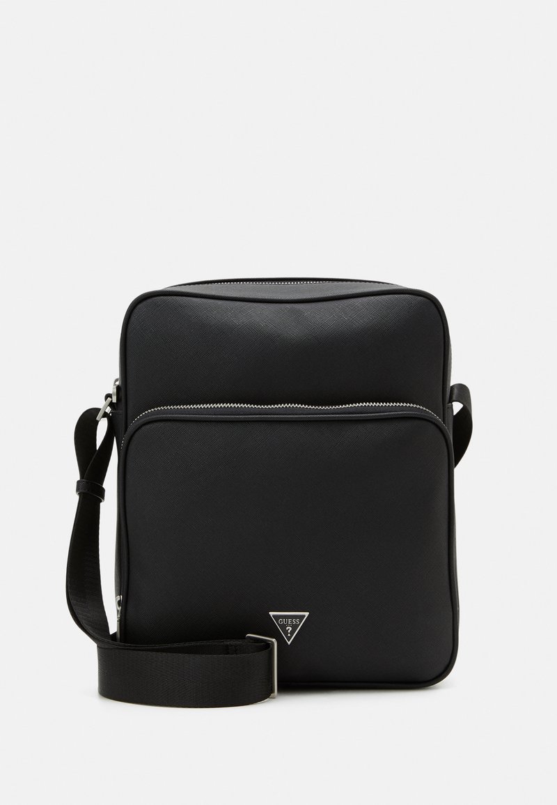 Sac à épaule synthétique noir avec une finition texturée, présentant une poche zippée à l'avant, une sangle réglable et un accent de logo en triangle.