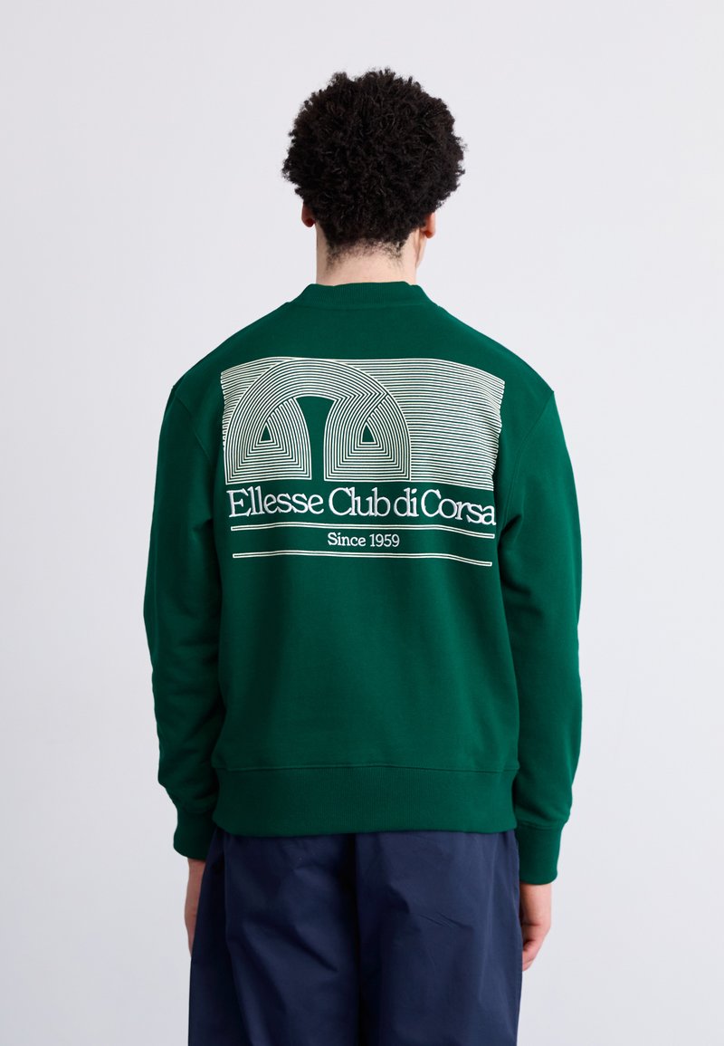 Sudadera de algodón verde con un diseño gráfico blanco que presenta líneas curvas y el texto 'Ellesse Club di Corsa' en la parte trasera. Textura suave.