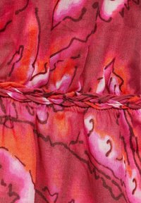 Textil que presenta una mezcla de tonalidades rosa y roja con patrones abstractos. Detalle trenzado notable en la cintura. Tela suave y ligera.