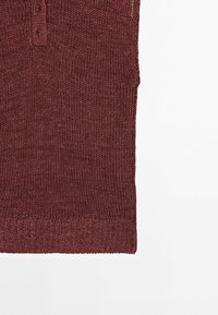 Pull sans manches en maille bordeaux avec encolure boutonnée et ourlet côtelé sur fond blanc.
