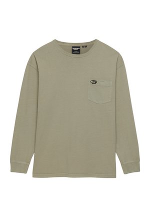Beige long-sleeve crewneck shirt with a chest pocket featuring a small oval black and white logo patch.