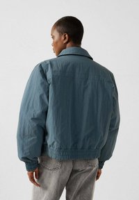 Teal bomberjack met lange mouwen, elastische manchetten en zoom, uitgerust met een opgerolde kraag en lichtgewicht, gestructureerde stof.