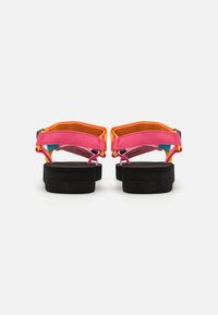 Flerfargede sandaler med rosa, oransje og blå stropper og en svart, kraftig hæl, som viser livlige tekstilmaterialer og solid konstruksjon.