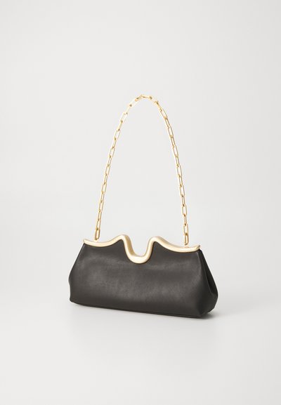 Black leather handbag with a wavy gold trim, featuring a gold chain handle and a soft, structured shape.