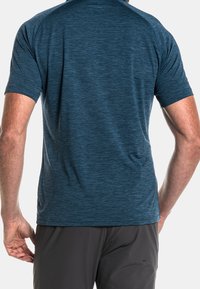 Kortärmad, atletisk blå T-shirt med en melerad textur, med rundad halsringning och raglanärmar, designad för komfort och rörlighet.