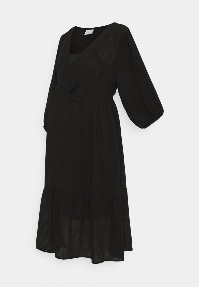 Robe midi noire avec manches longues bouffantes, col en V, taille nouée et ourlet à volants, exposée sur un mannequin sur fond blanc.