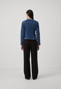 Donkerblauwe denimjack met lange mouwen en een getailleerd ontwerp. Kenmerkt zich door een licht cropped snit, zichtbare naden en geen versieringen.