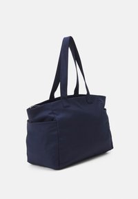 Marinblå axelväska i kraftigt tyg, med två långa handtag, dragkedjestängning och en sidoficka för extra förvaring.