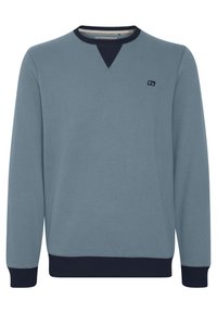 Lyseblå sweatshirt med rund halsudskæring, marineblå detalje ved kraven, ribbede manchetter og kant, samt et lille logo på brystet. Blød tekstur.