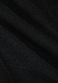 Mustast kangast, millel on pehme ja tekstuuriga pind ning peened sügavuse variatsioonid. Voltidega, millele varjud lisavad disaini esiletoomist.