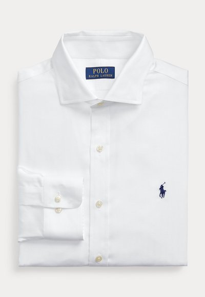 White long-sleeve dress shirt with a pointed collar, featuring pearl buttons and a small navy logo on the chest. Herringbone texture.