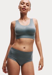 Šedý bezšvový bralette a vysoké kalhotky, obojí vyrobené z pružného, hladkého materiálu. Jednoduchý design bez viditelných švů nebo vzorů.