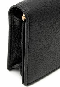 Czarny, teksturowany skórzany portfel z widocznym szwem i małym złotym metalowym zapięciem na białym tle.