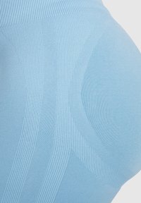 Leggings azzurri chiari con un motivo a costine strutturato, dettagli lisci e cuciture sagomate per un aspetto aderente.