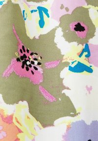 Bloemenstofontwerp met grote, abstracte bloemen in roze, groen, geel en blauw, met een zachte, gestructureerde oppervlakte.