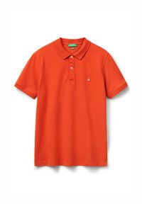 Jasně oranžové polo tričko s krátkým rukávem, se dvěma knoflíky, malým bílým a červeným logem na levé straně hrudi a zeleným štítkem značky uvnitř límce.