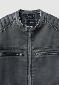 Giubbotto in pelle sintetica nera con colletto rotondo, chiusura frontale con zip e due tasche sul petto. Presenta una texture a coste sulle spalle e un design senza cuciture.