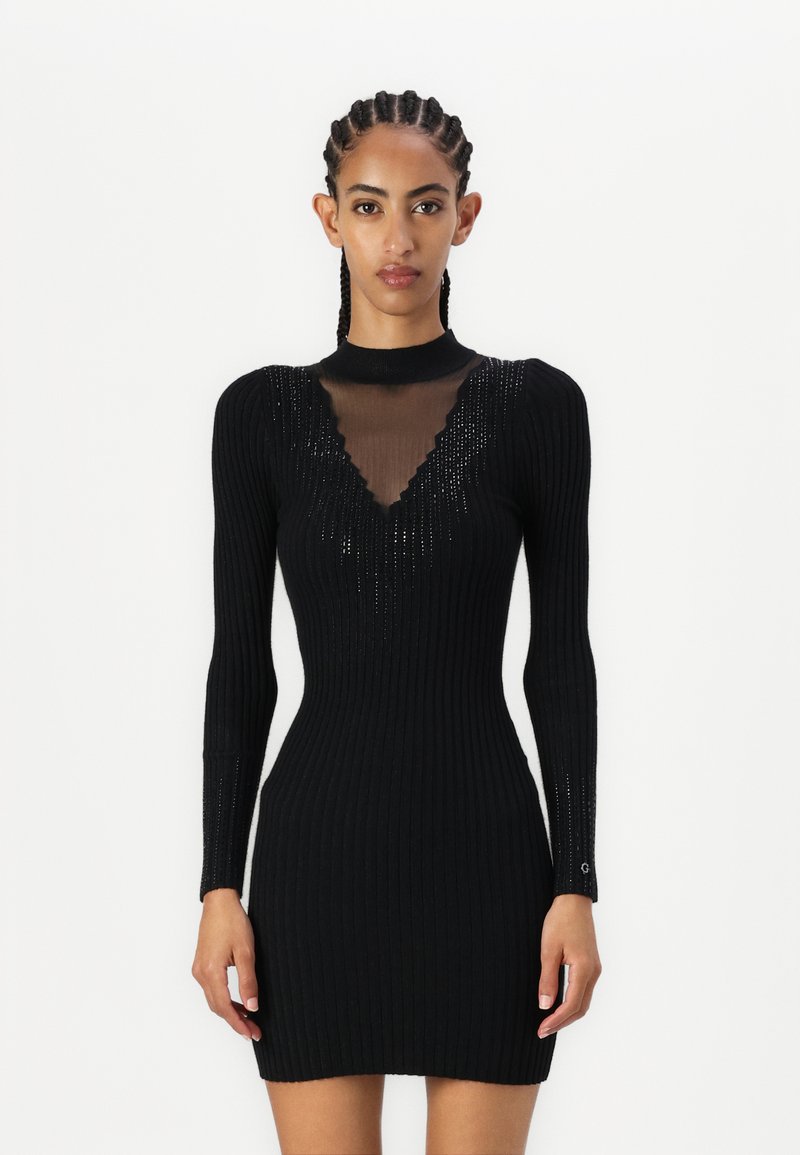 Vestito nero a costine con maniche lunghe, con un neckline a V in rete e accenti scintillanti sulle spalle. Vestibilità slim, texture morbida.