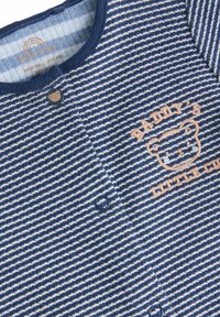 Tutina a righe blu e bianche con bottoni a forma di orso, con testo ricamato "Il piccolo cucciolo di papà" e un design di orso sorridente.
