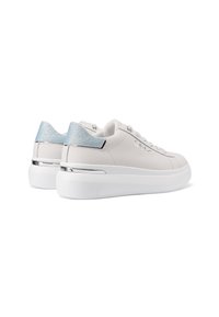Sneaker bianche con una texture in pelle liscia, dettagli argentati sul tallone e un leggero luccichio azzurro sul tab del tallone. Suola bianca spessa.