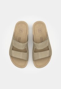 Bežne slidne sandale v bežni barvi z dvema nastavljivima trakoma, teksturirano površino in oblazinjeno notranjostjo, z embosiranim logotipom blagovne znamke na podplatu.
