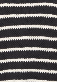 Gros plan sur un tissu noir tricoté avec des rayures blanches horizontales uniformément espacées.