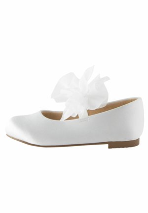 Ballerine en satin blanc avec un bout arrondi et une fleur en ruban transparent décorative sur la sangle. Semelle plate en caoutchouc texturé.
