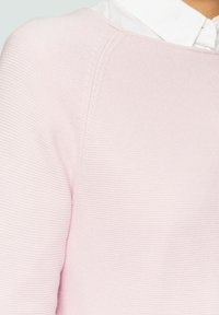 Helles rosa gestricktes Sweatshirt mit strukturiertem Oberflächen. Verfügt über einen runden Halsausschnitt und leicht senkbare Schultern. Weiches und lässiges Design.