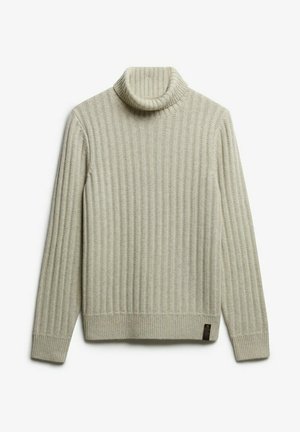Beige ribbed turtleneck sweater lavet af strikket materiale. Den har en høj, rullet krave og et lille logo mærke på den nederste side.