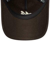 Casquette marron avec une visière plate, dotée d'un matériau texturé et de coutures noires. L'intérieur a un revêtement doux et sombre avec un support central.