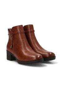 Botas de cuero marrón hasta el tobillo con punta redondeada, detalle envolvente alrededor del tobillo y un resistente tacón cuadrado para mayor estabilidad. Textura suave.