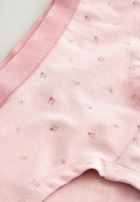 Sous-vêtements en coton rose clair avec une ceinture élastique douce et de petits motifs floraux en violet et vert. Texture lisse et bords arrondis.