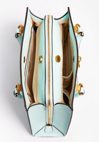 Kaksiosainen käsilaukku pehmeää mintunvihreää nahkaa, jossa on kultaiset yksityiskohdat. Laukussa on vetoketjukiinnitys ja vaaleanruskea sisustus, jossa on taskuja.