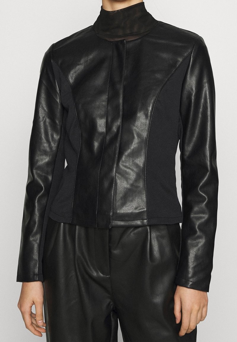 Czarna skórzana i materiałowa kurtka z wysokim kołnierzem, o dopasowanym kroju i kontrastowych panelach, gładkiej fakturze oraz zapięciu na zamek.