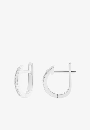 Een paar zilveren kleine oorringen met een rij kleine heldere edelstenen langs de buitenrand en een steker sluiting.