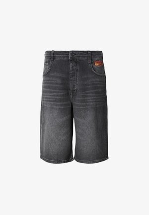 Mustad teksapüksid, millel on sirge lõige, viis taskut ja vöökohal tikitud silt. Tekstureeritud kangas tuhmunud viimistlusega.