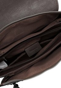 Brown leather bag interior with multiple compartments, including zippered sections and a fabric lining, features a textured finish.