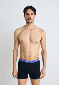 Black men's boxer briefs with a blue elastic waistband featuring the brand "BJÖRN BORG." Smooth fabric, fitted shape, no visible patterns or accents.