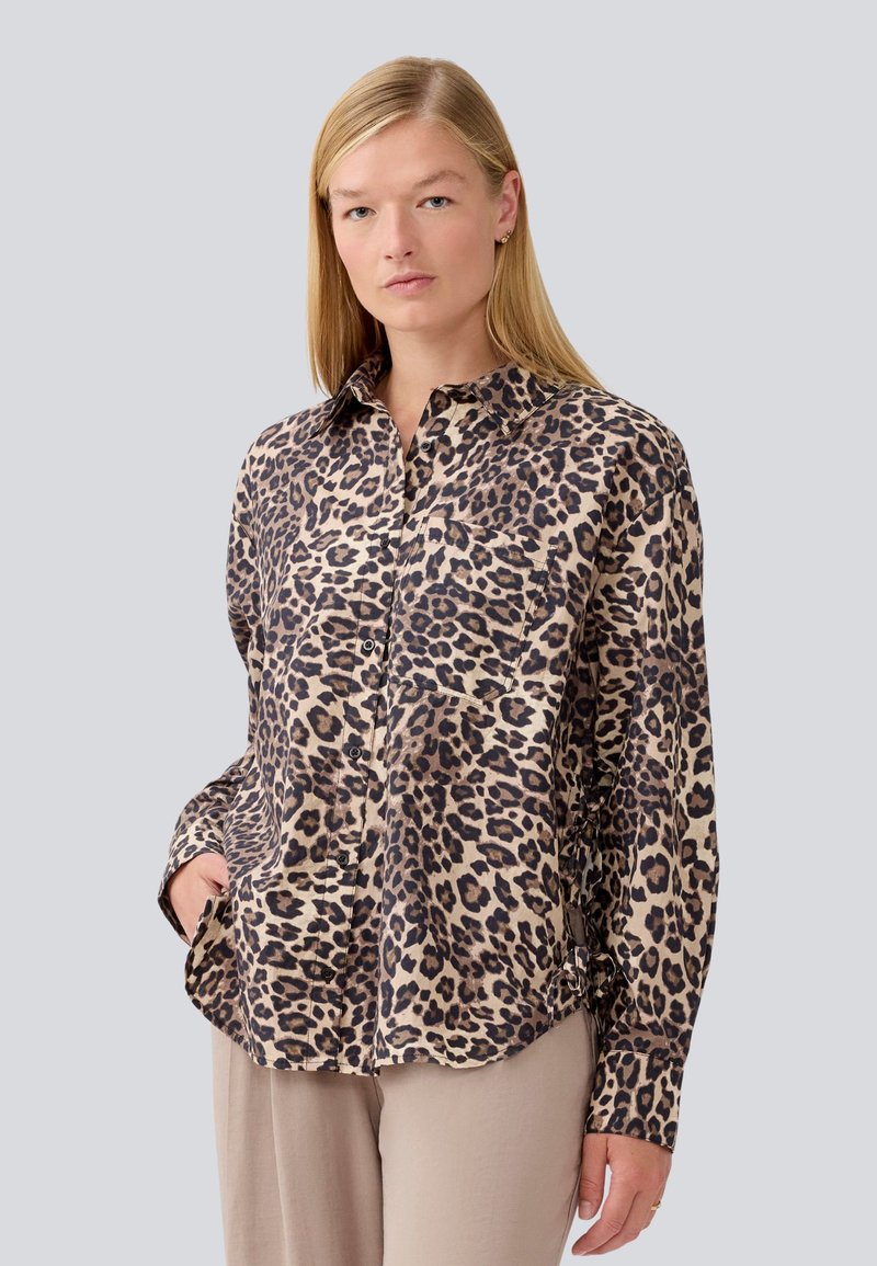 Camicia a maniche lunghe con stampa leopardata in tessuto leggero, con chiusura a bottoni e tasca. Presenta un colletto e una vestibilità rilassata.