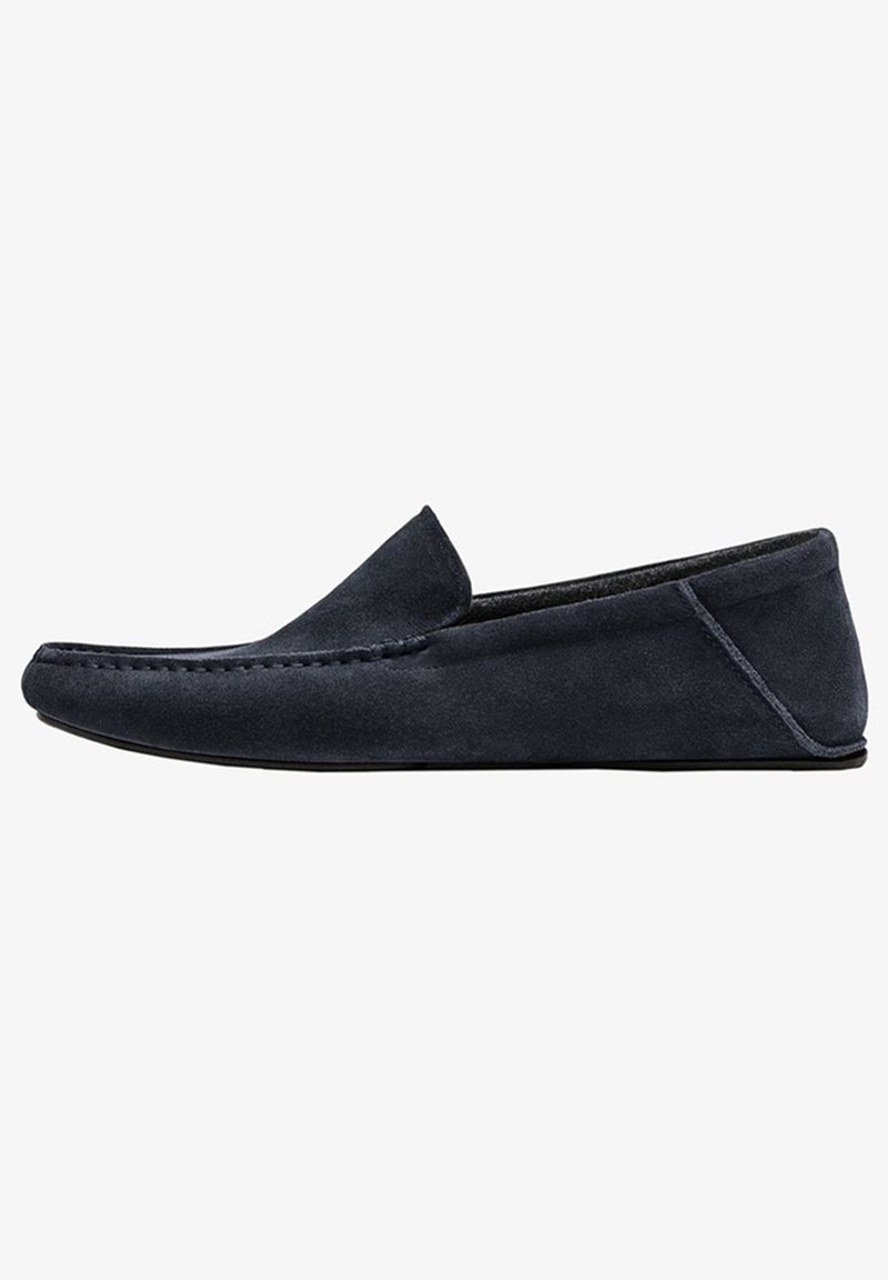 Mocassin pour homme en daim bleu marine à enfiler, avec détail de couture sur le bout et semelle noire profilée basse, vu de côté.