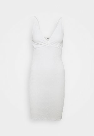 Robe blanche ajustée en tissu texturé et froissé. Présente un décolleté en V profond et des bretelles étroites, avec un ourlet légèrement effiloché.