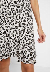 Schwarz-braues Leopardenmuster-Kleid mit ausgestelltem Saum, aus leichtem Stoff gefertigt, mit Falten und einer glatten Textur.