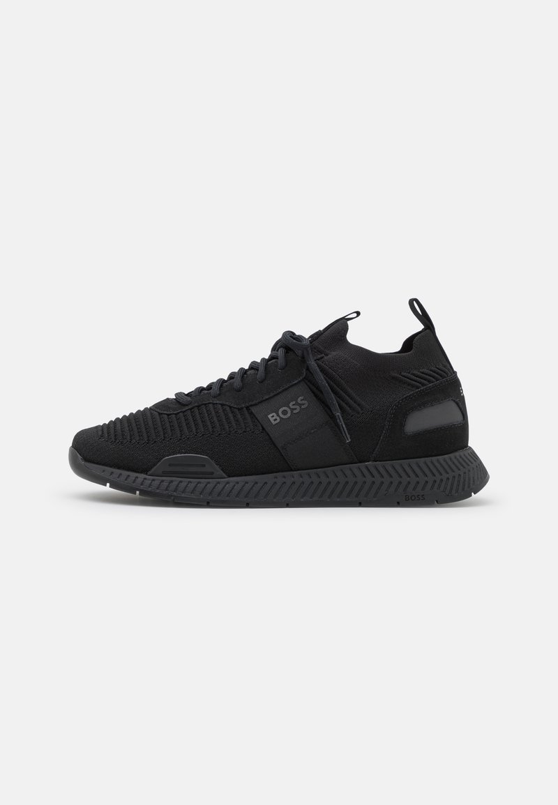Sneaker en maille noire à lacets avec semelle texturée, languettes au talon et à la languette, et logo « BOSS » sur le côté et la semelle.