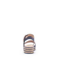 Sandale en cuir bleu marine avec sangle arrière, semelle en liège à rainures horizontales et design à orteil arrondi.
