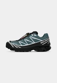 Trailrunning schoenen in turquoise en zwart, met een textuur bovenwerk, reflecterende accenten, GORE-TEX branding en een vetersluiting systeem.