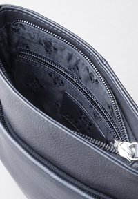Black leather bag with a textured finish, featuring multiple zippered compartments and a smooth interior lining.