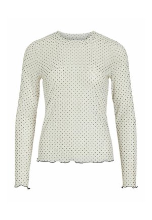 Top de manga larga en blanco con lunares negros. Presenta un escote redondo, dobladillo con borde en forma de ondas y detalle de puño en las mangas. Tejido suave y ligero.